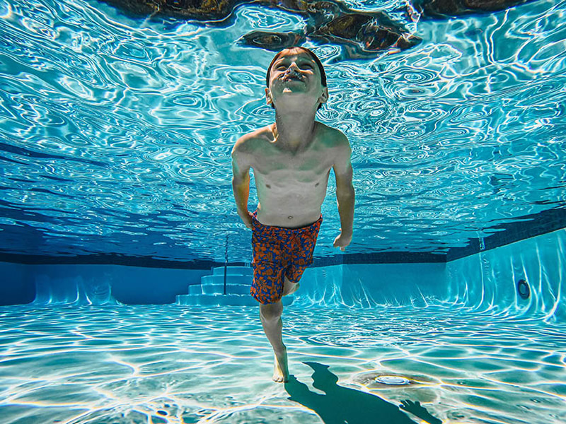 A young boy swims underwater