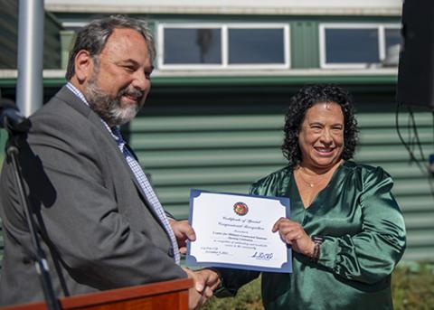 Kari Leslie receives a resolution in support of the Center for Military-Connected Students from Greg Haas from Congressman Carbajals office