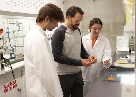 Cal Poly Professor Phil Costanzo and two students examine a tube of D-Glue in a lab