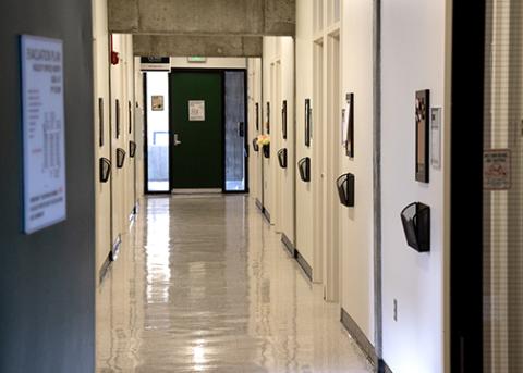 A row of doors seen from an aisle inside a Cal Poly building