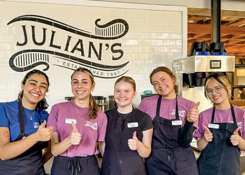 Five female employees at Julians give a thumbs up