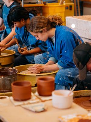 Students use a pottery wheel to craft clay 