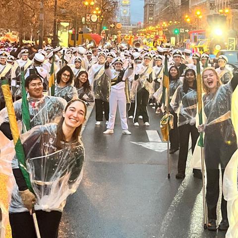 Marching band poses during parade in San Francisco to take a picture while it is raining