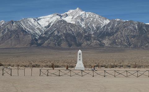 Snow-covered Sierra peaks rise east of the Manzanar Cemetary Monument in Owens Valley California