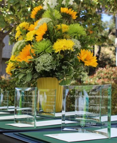 Awards are seen on a table with colorful flowers