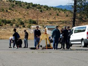 A group of architecture students work on surveying equipment