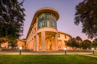 A view of the facade of the Orfalea College of Business at dusk.