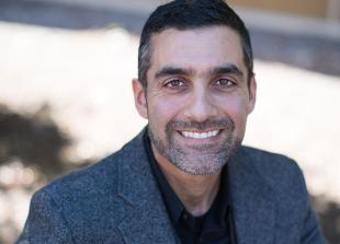 Cal Poly professor Aydin Nazmi, smiling in a grey jacket