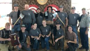 The Cal Poly Logging Team holds axes and plaques after taking first in a timbersports competition