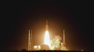 With orange flames shining against a dark sky, NASA's Artemis I flight test launches from Kennedy Space Center in Nov. 2022.