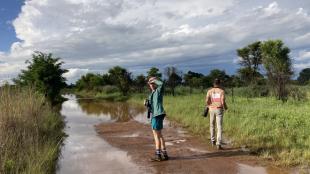 Student TJ Samojedny walks down a muddy dirt road in South Africa as he conducts field work.