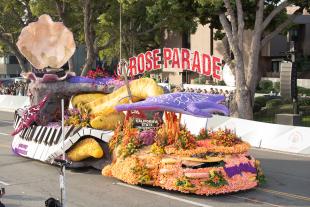 The 2024 Rose Float rides down the street covered in musical scenes.