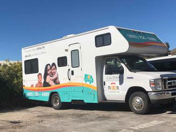 Cal Poly's Mobile Health Unit, which was formerly an RV, is parked in a parking lot. 