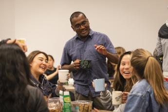 Professor Nishi Rajakaruna, center, laughs with five students during one of his tea parties at Cal Poly.