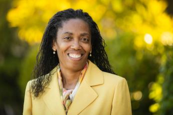 New provost Cynthia Jackson-Elmore smiles on campus in a yellow jacket