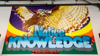 A mural, "Rooted in Native Knowledge," by Joel Garica, featuring a red-tail hawk