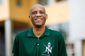 Biomedical engineering professor Michael Whitt wears a green polo shirt with a National Society of Black Engineers logo on the chest