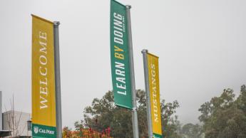 An image of the banners at the entrance to the Cal Poly campus on a rainy day.