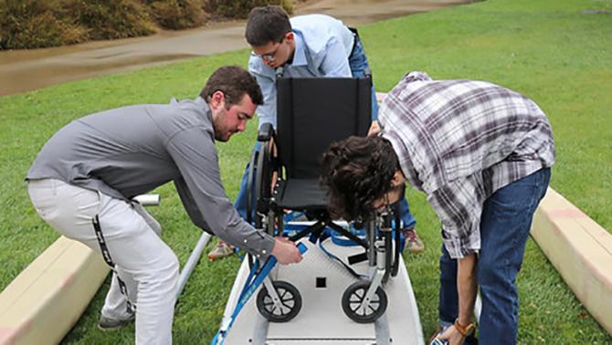Mechanical Engineering students with paddleboard they created for use with those with spinal cord injuries.