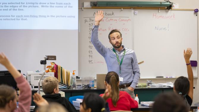 Cal Poly Student Teacher works with students in a 7th grade science class inside a classroom. 