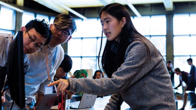 Selynna Sun helps students during a hackathon