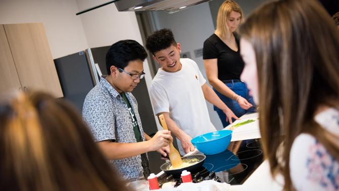 Students work together in a dorm kitchen. 