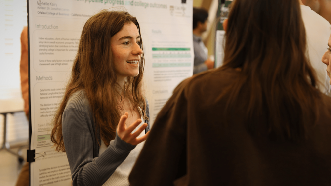 A student presents her research findings to a group of people