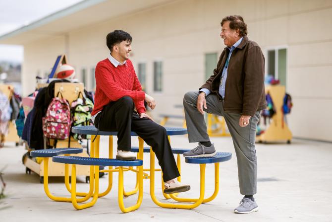 Ramon Gutierrez, left, laughs with his mentor, Juan Olivarria, right, on the campus of Grover Beach Elementary School.