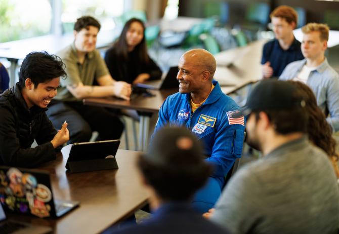 Victor Glover meets with students in an engineering classroom.