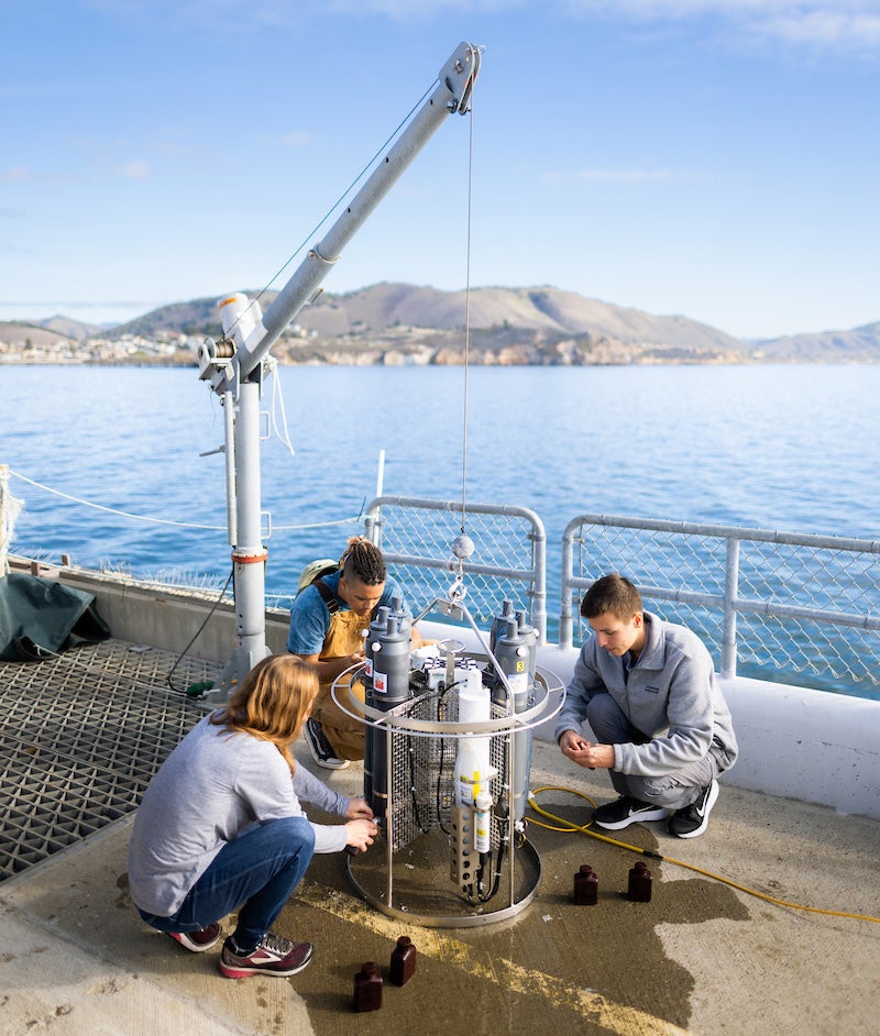 Students prep and deploy a seawater collection device off the Cal Poly Pier.