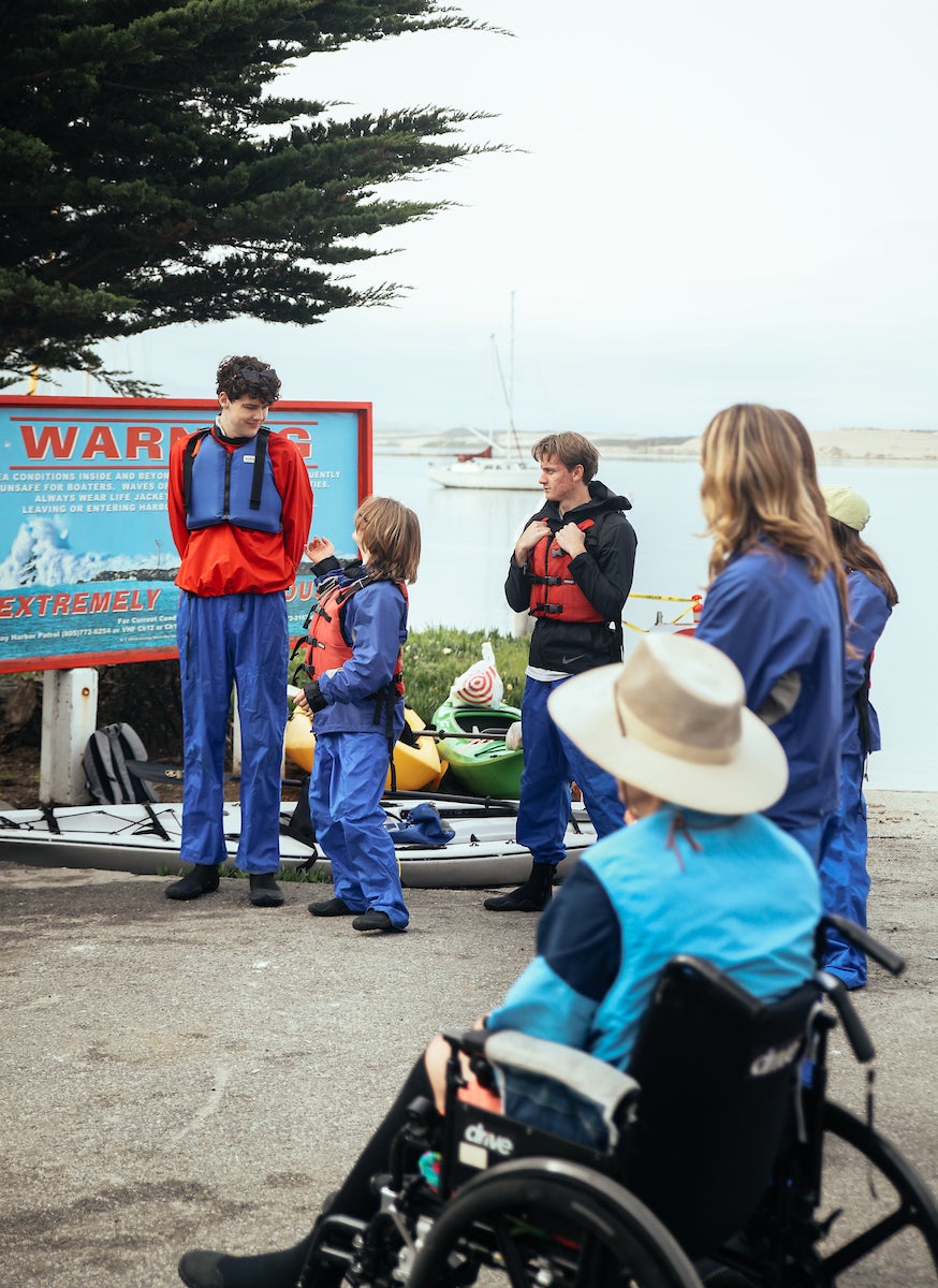 Luke Hansen stands and smiles with community members in Morro Bay.