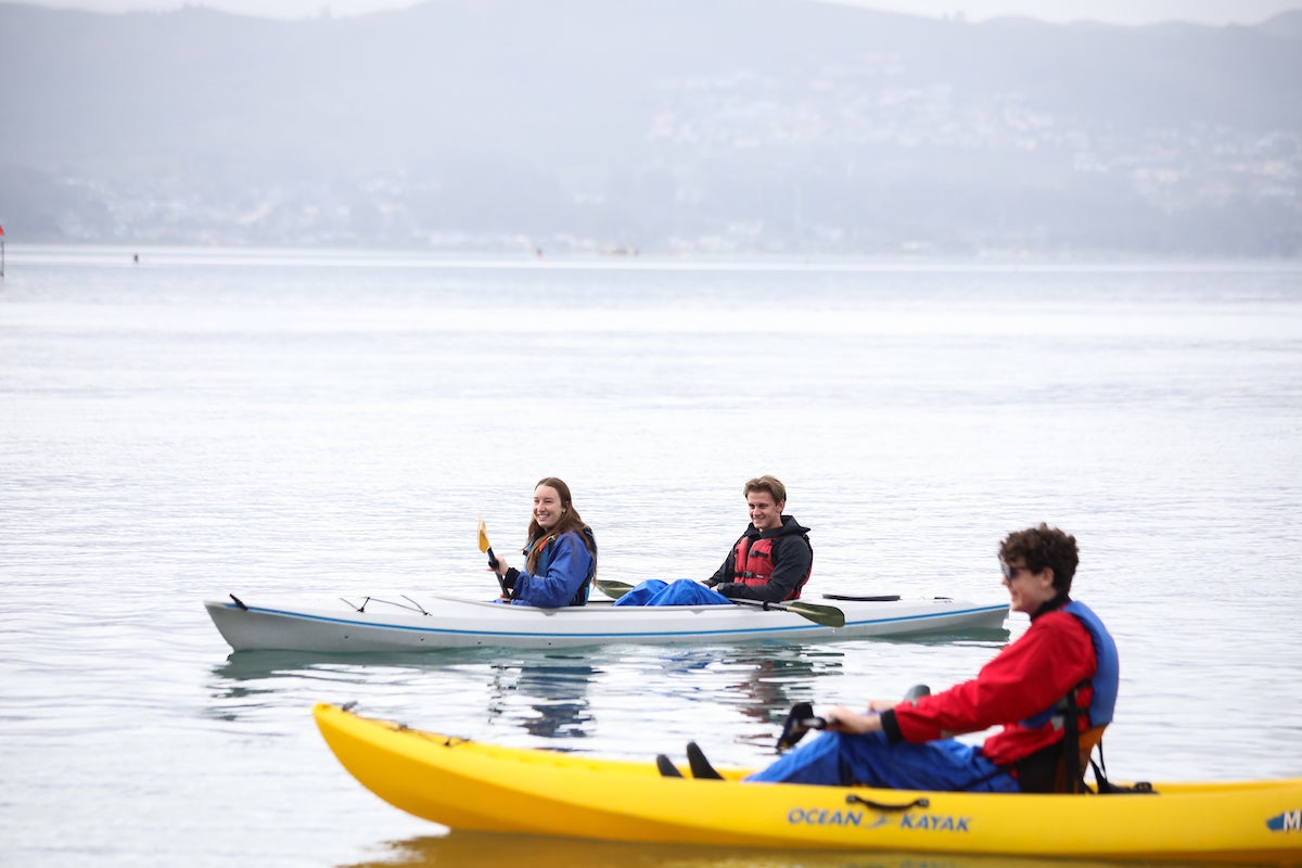 Luke Hansen in the foreground with other kayakers in the background in Morro Bay.
