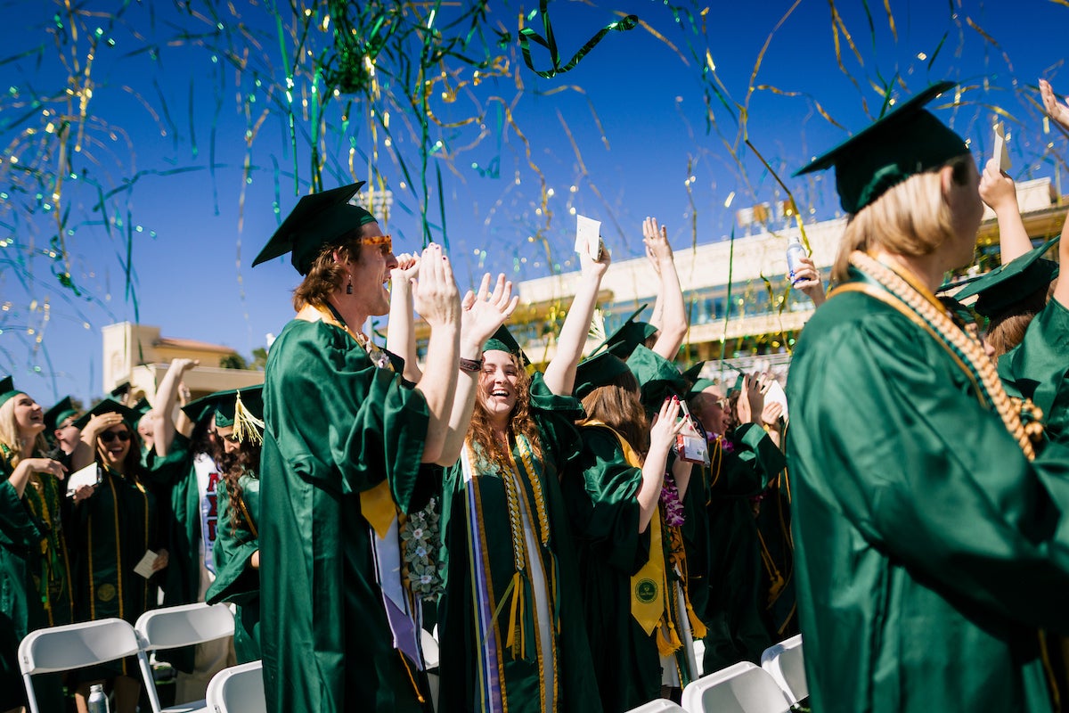 Graduates clap and cheer as streamers rain down around them at last year's commencement ceremony.
