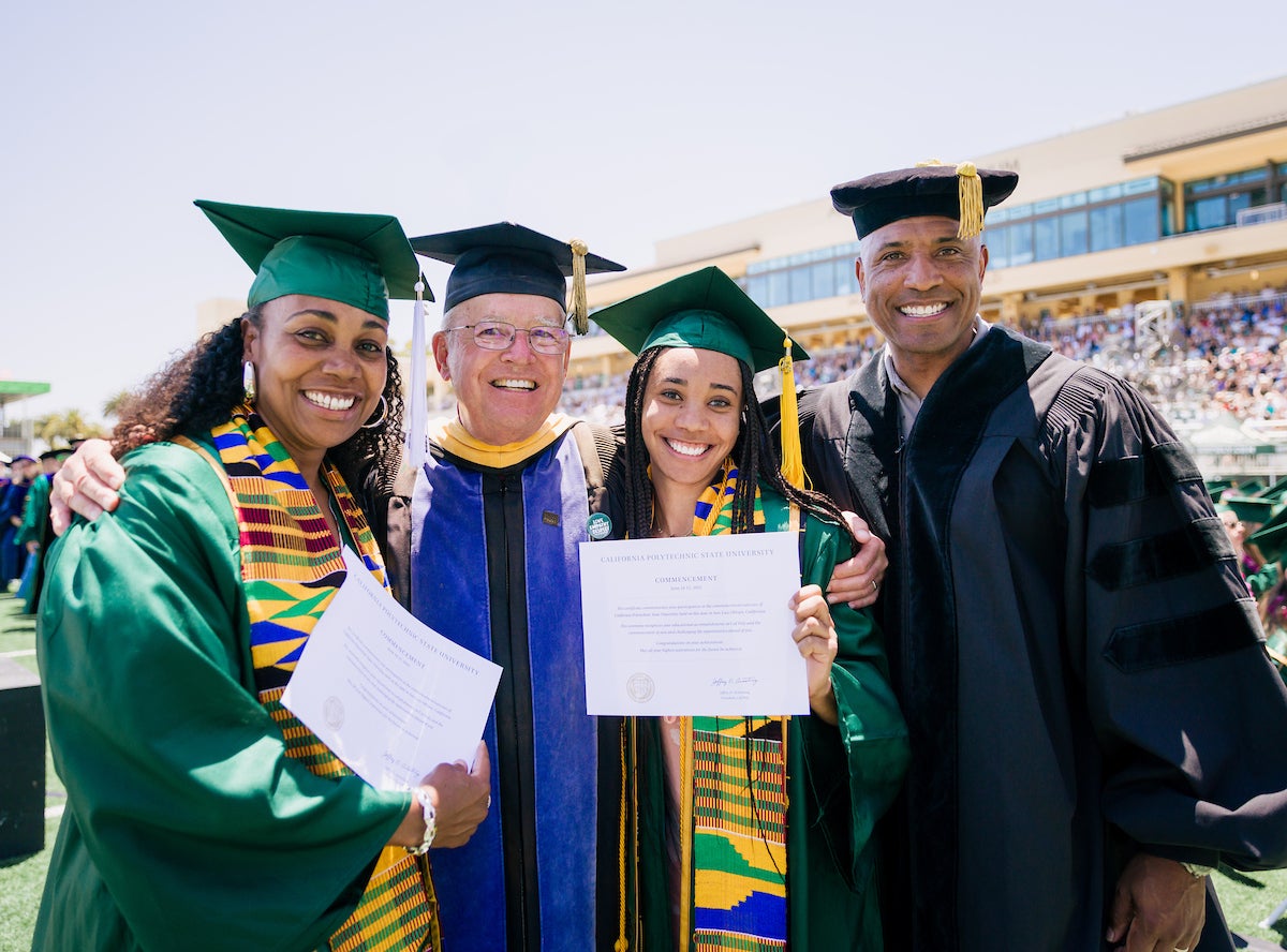 Dionna Glover, dean emeritus Phil Bailey, Genesis Glover and Victor Glover smile for a picture at Spanos Stadium during commencement.
