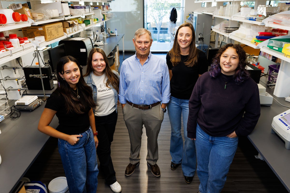 Five researchers pose for a group photo in a lab.