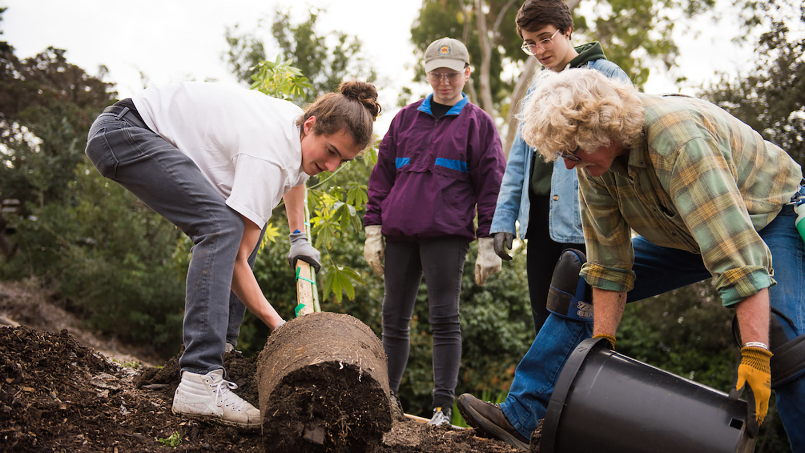 Michael Bush, the Director of the San Luis Obispo Botanical Garden, planting a tree with students
