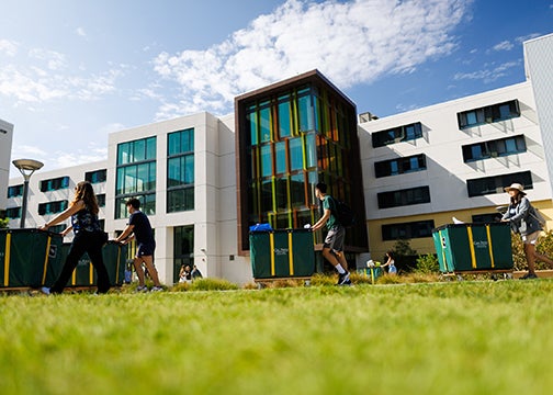 Freshmen students push carts containing belongings to the YTT student housing complex in 2022