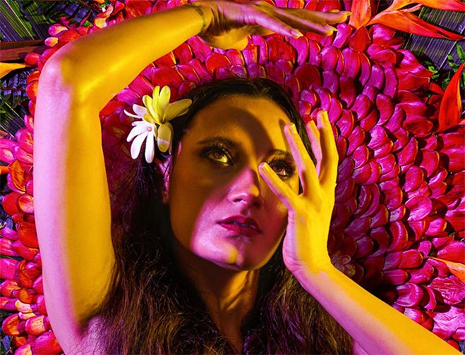Taimane image features a woman in front of a colorful circular floral backdrop  