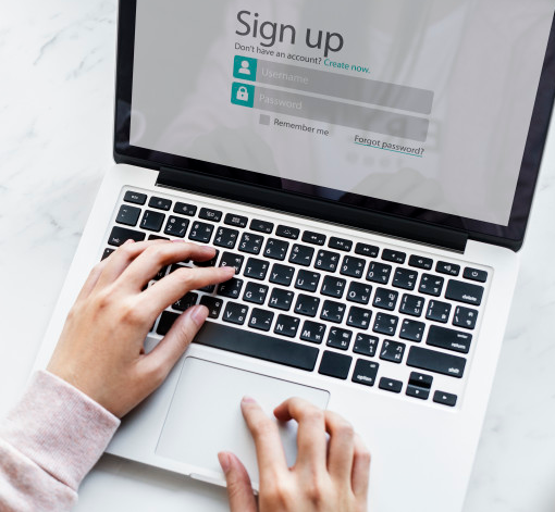 A person types on a computer, the screen reads Sign Up