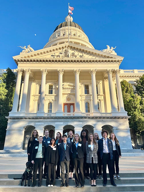 Nineteen Cal Poly students pose in front of the state Capitol building in Sacramento, Calif.