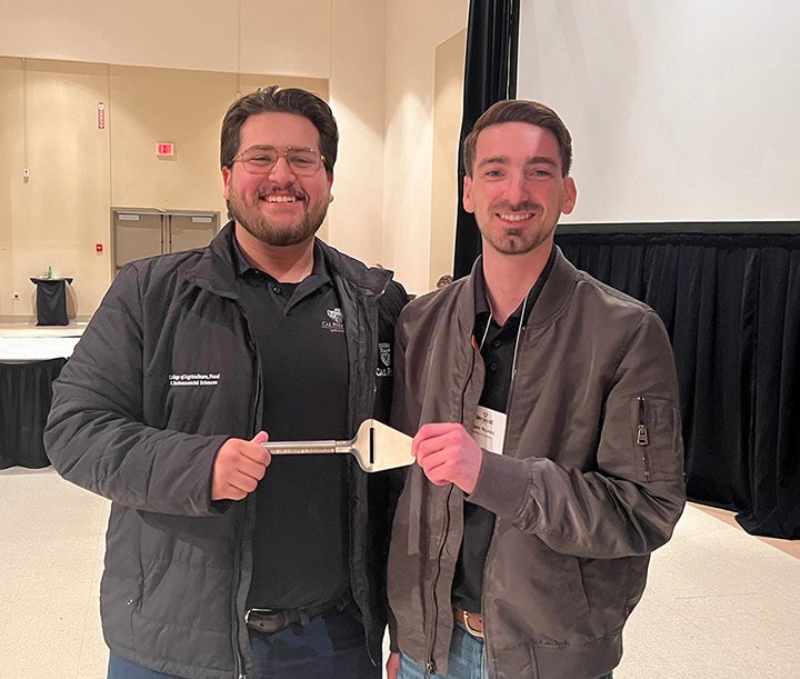 Third-year Teddy Lopez, left, and fourth-year Ryan Nunes, both agricultural science majors, pose after Cal Poly’s student-produced Triple Peak brie was awarded the first-place title.