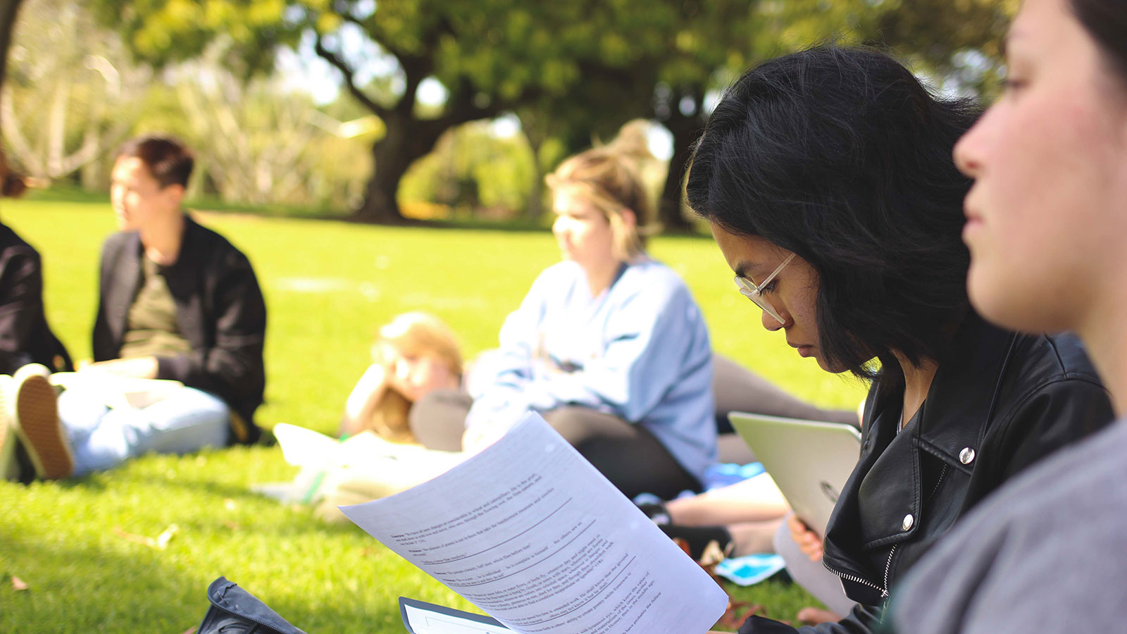 English students reading outside on campus