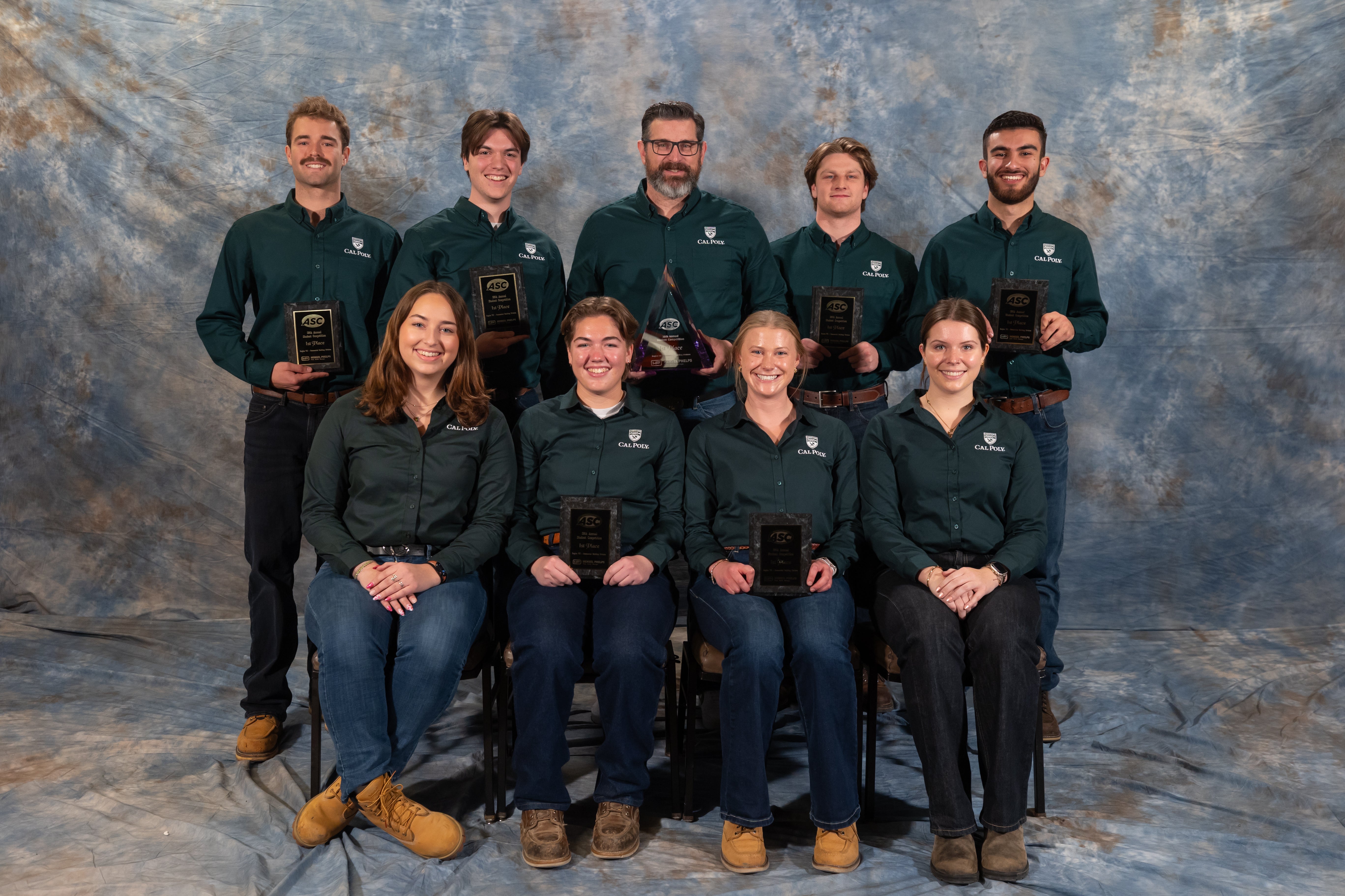 A team of Cal Poly students hold awards as they pose for a photo.