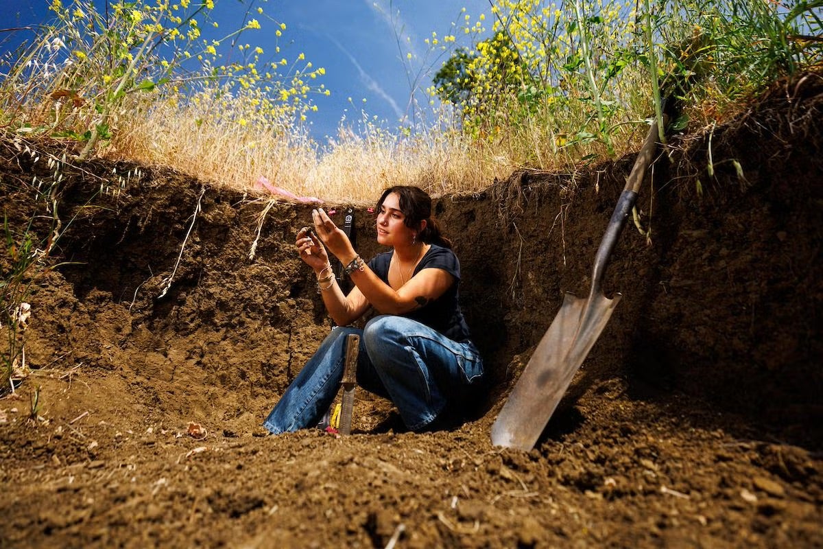Nabila Wildman collects a soil sample.