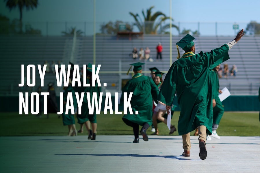 A graduate walk at commencement with text that reads “joy walk. Not jay walk.”