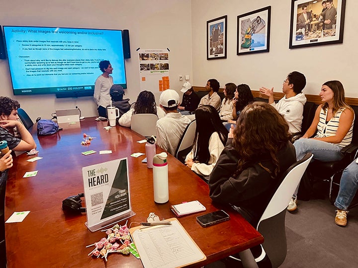 Students at a conference table providing feedback.