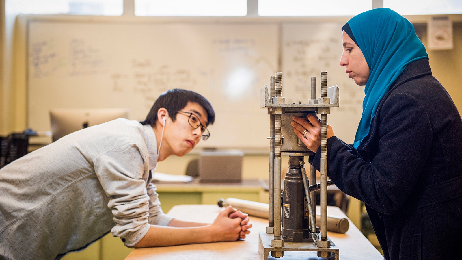 Two students working in the architectural soils lab testing structural pressure.