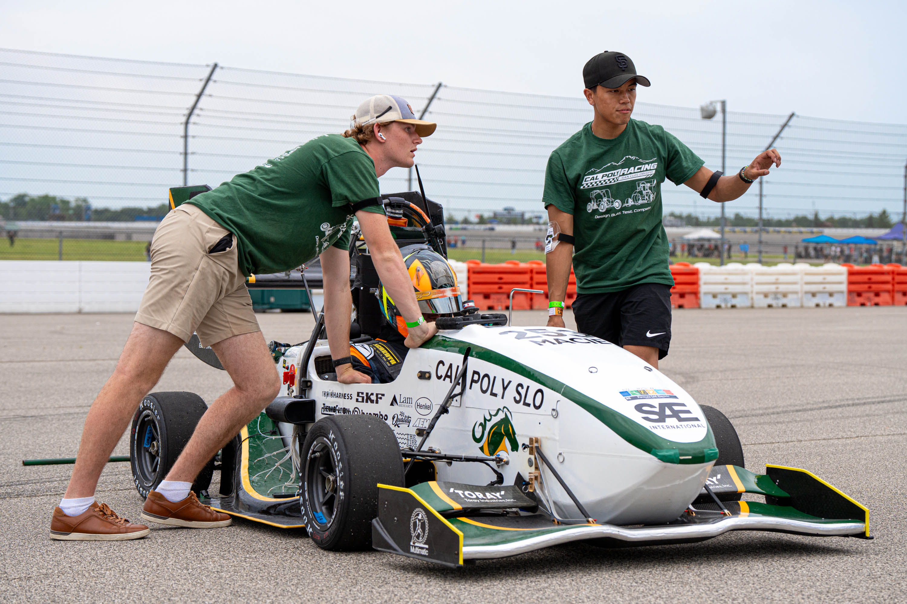 John O'Donnell speaks with two teammates, one in the race car, during a race.