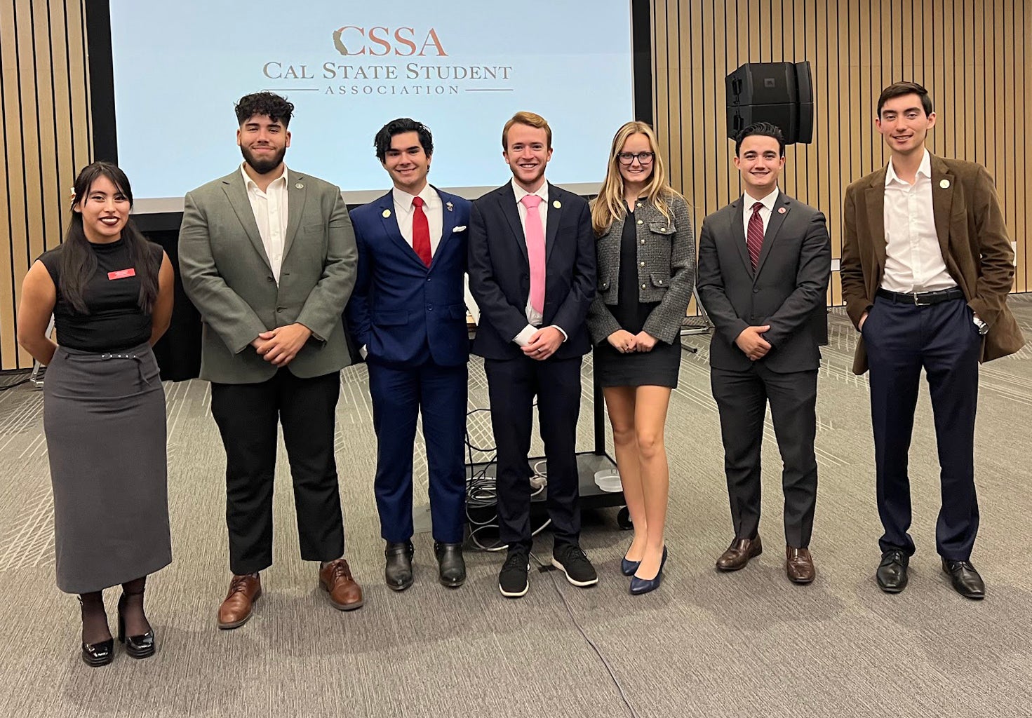 A group of students in business attire pose for a photo.
