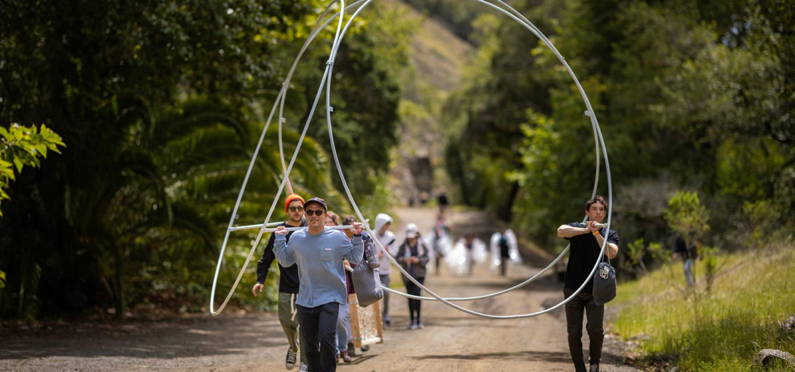 Students hike the mile-long trail with their materials before reaching Poly Canyon